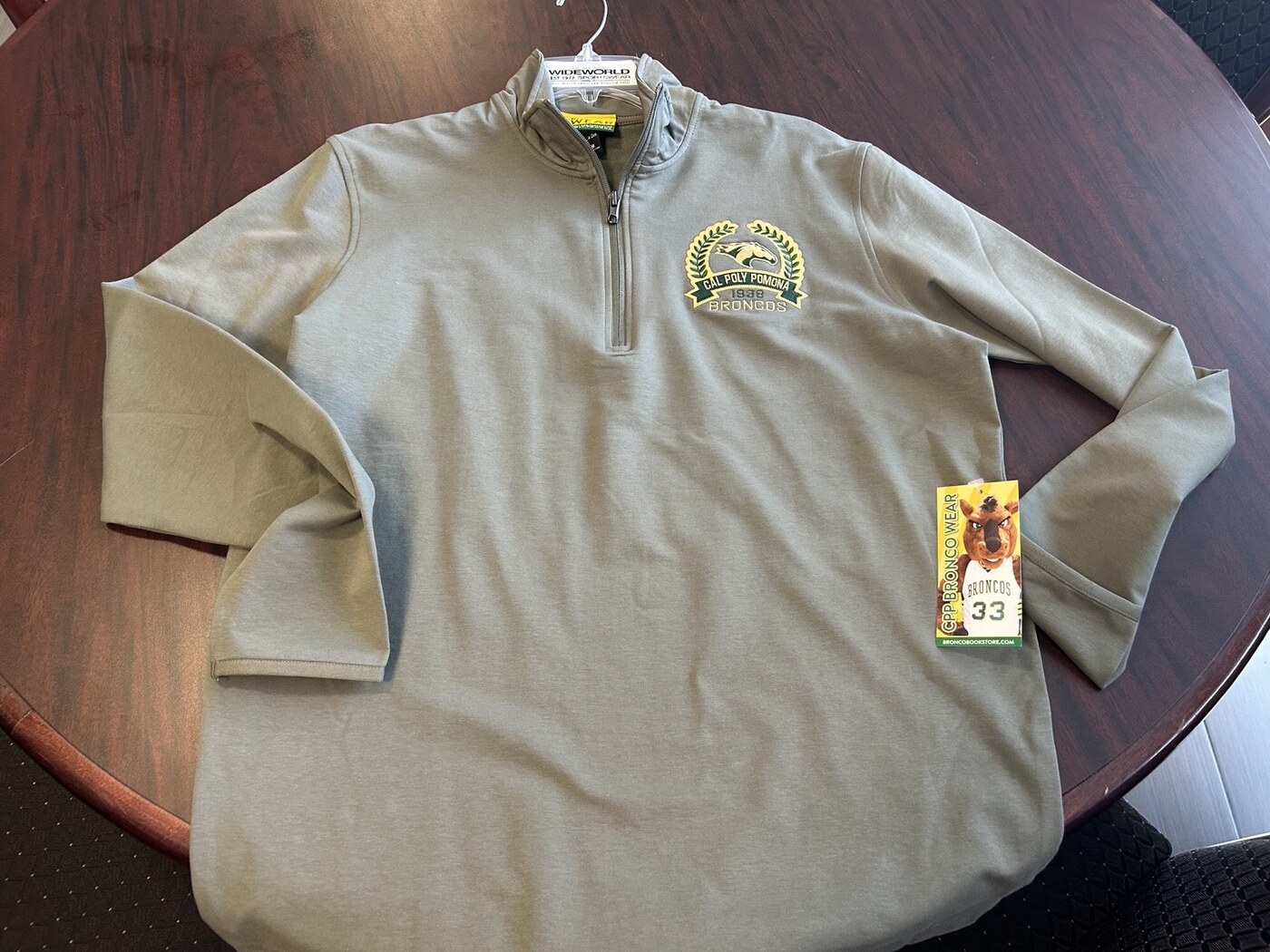Cal Poly Pomona quarter zip with an attached Broncos retail hangtag