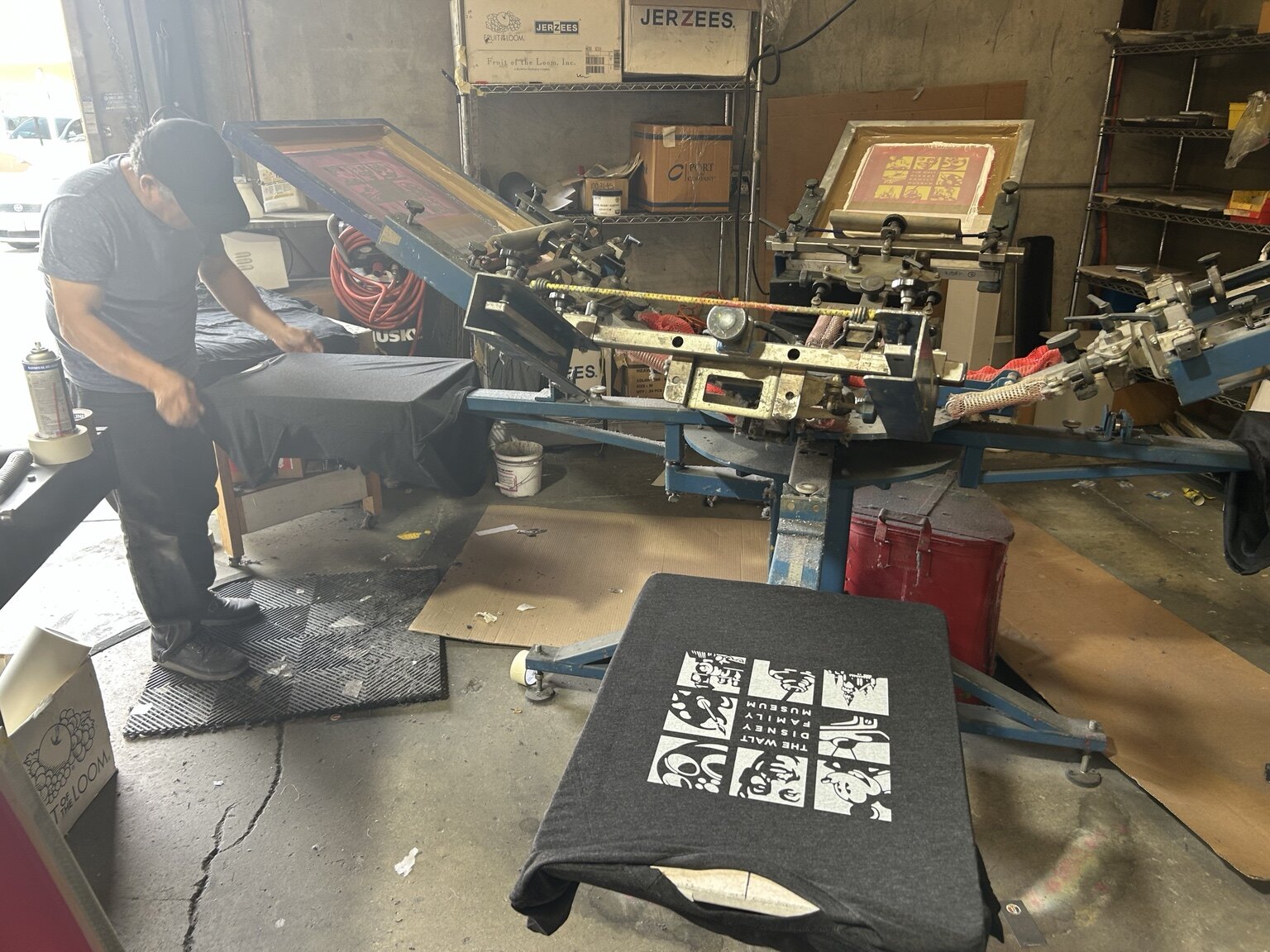 Wideworld team member screen printing a garment